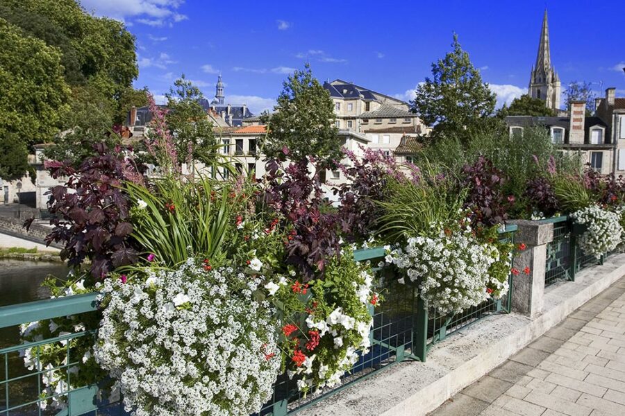 Vue du pont fleuri de Niort avec ses jardinières colorées, symbole d’une ville propre et engagée dans la gestion durable des déchets professionnels.