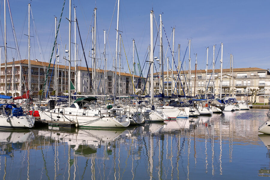Vue du port de Rochefort avec ses voiliers amarrés et leurs reflets sur l’eau, symbole d’une ville dynamique et respectueuse de l’environnement, engagée dans la gestion durable des déchets professionnels.